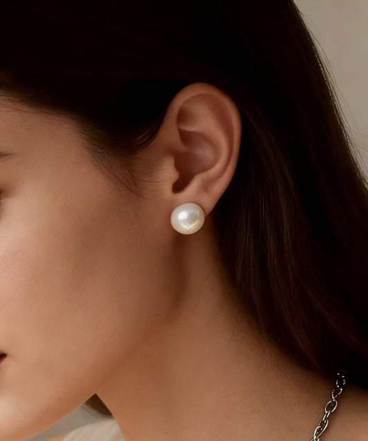 Woman wearing a 7mm white freshwater pearl stud earring with a sterling silver post.