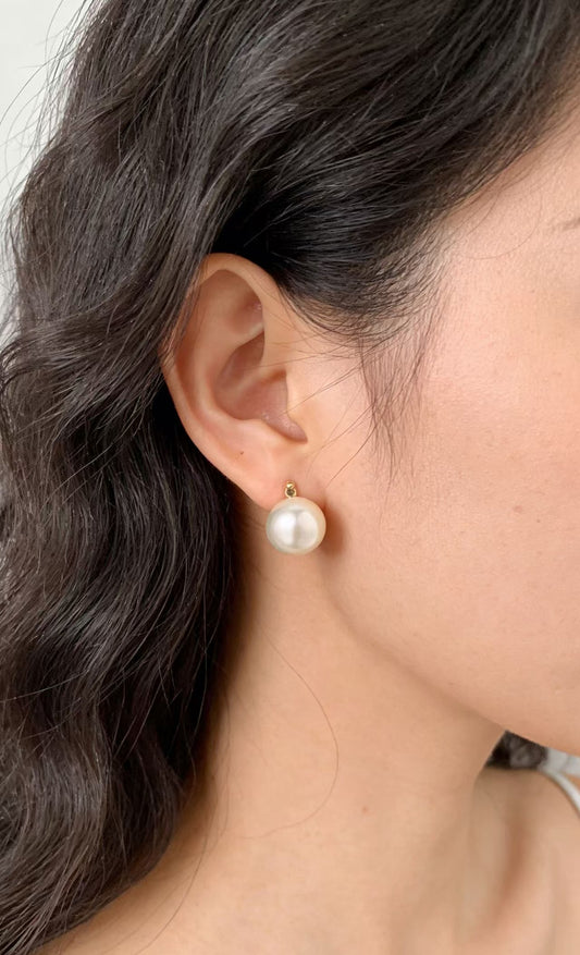 Elegant 6-7mm natural saltwater pearl stud earring with soft luster, worn on an ear.