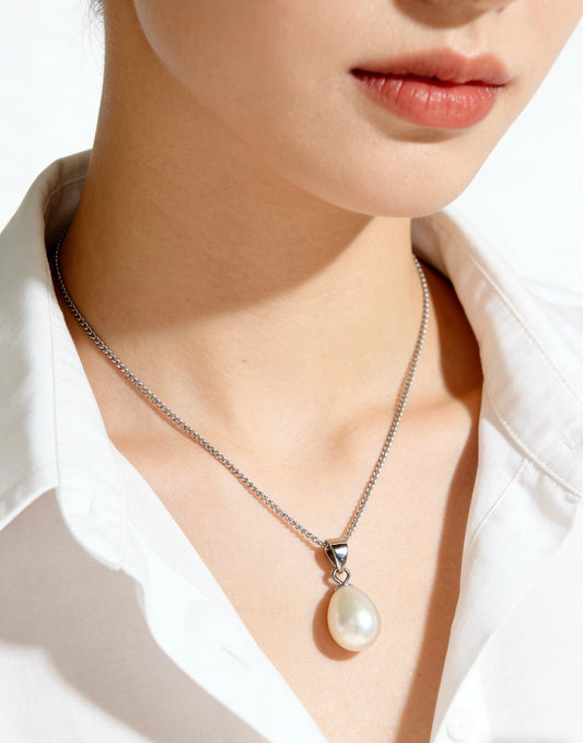 Woman wearing a minimalist baroque freshwater pearl pendant necklace with a 925 sterling silver chain.